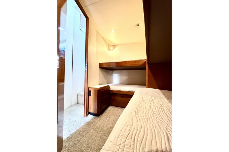 Slide: The Image of Interior cabin of 1999 Viking 43 Convertible yacht with bunk beds and wooden cabinetry. - 11