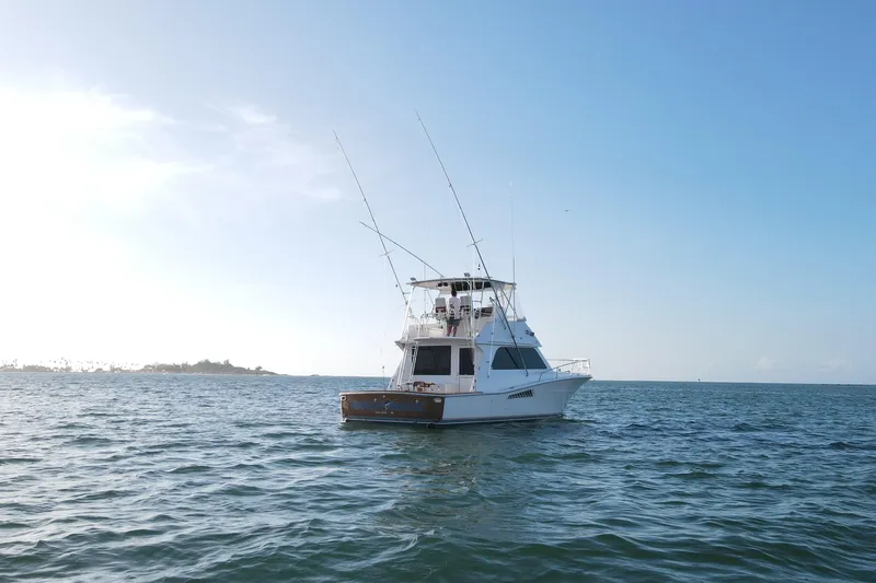 Slide: The Image of 1999 Viking 43 Convertible yacht on open sea under clear blue sky. - 4