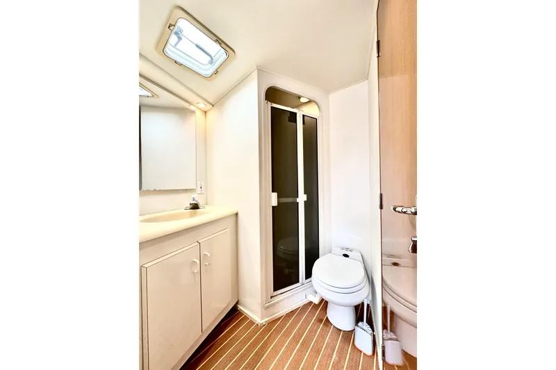 Slide: The Image of Bathroom interior of 1999 Viking 43 Convertible yacht, featuring shower, toilet, and vanity. - 5