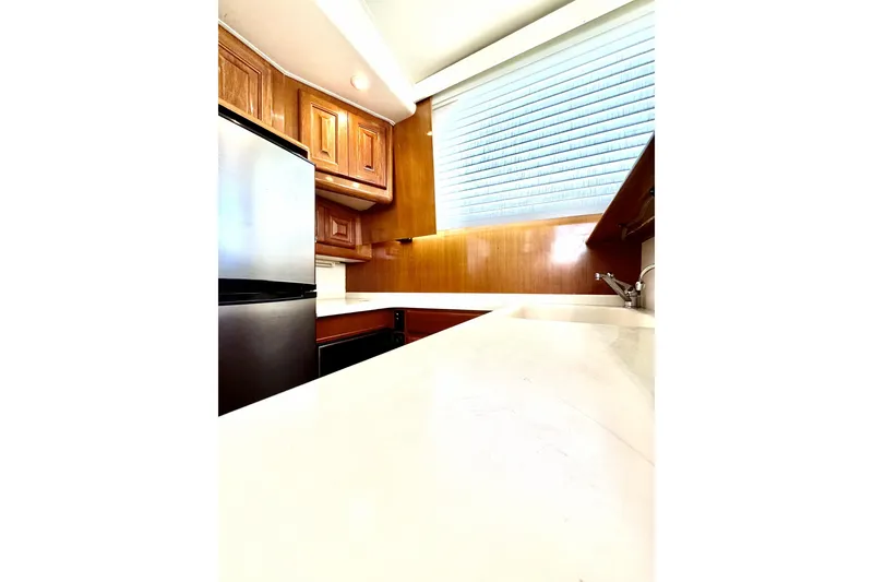 Slide: The Image of Interior of 1999 Viking 43 Convertible yacht kitchen with wooden cabinets and stainless steel appliances. - 6