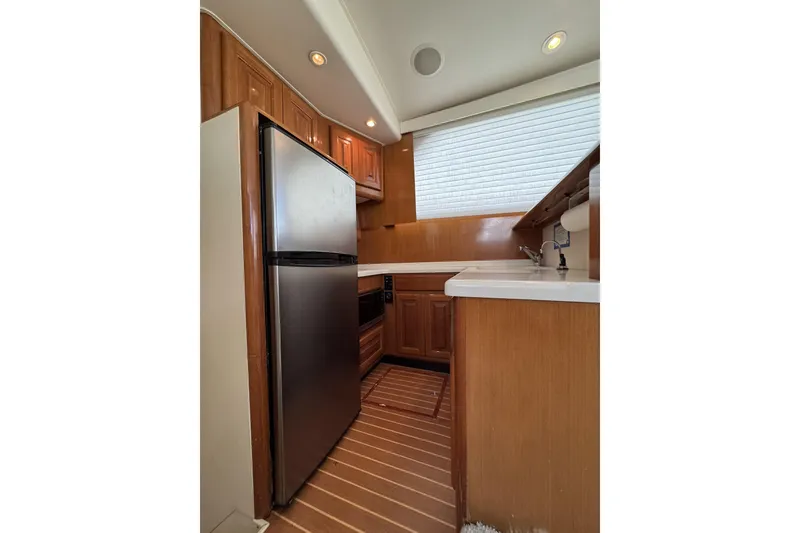 Slide: The Image of 1999 Viking 43 Convertible yacht kitchen with wood cabinetry and stainless steel appliances. - 7