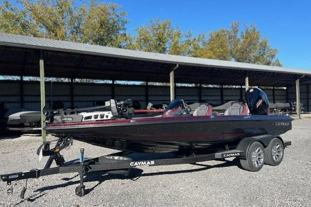 Slide: The Image of 2026 Caymas CX 20 PRO boat on trailer, parked outdoors under a metal canopy. - 9