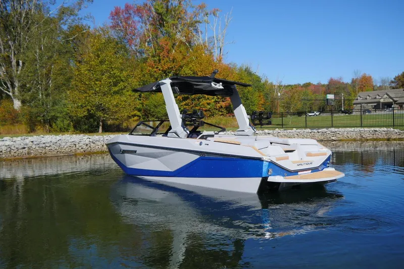 Slide: The Image of 2026 Nautique Super Air Nautique G23 boat on calm water, surrounded by autumn trees. - 15