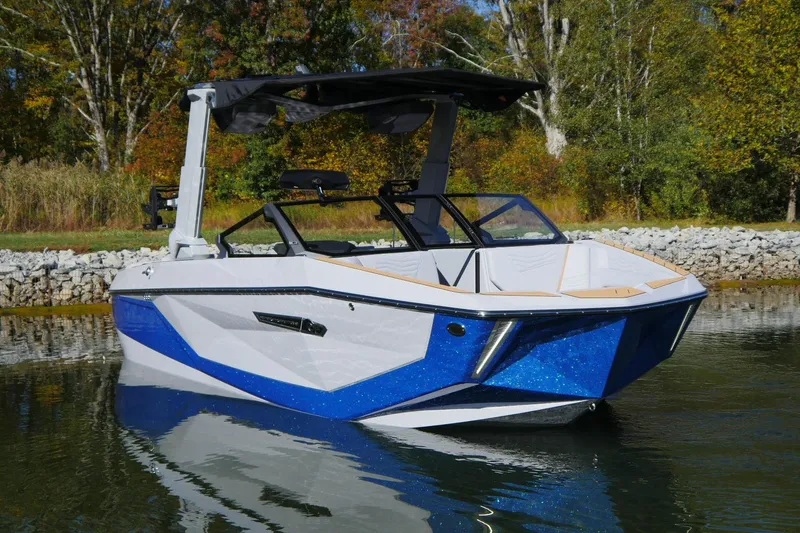 Slide: The Image of 2026 Nautique Super Air Nautique G23 boat on calm water, surrounded by autumn trees. - 18