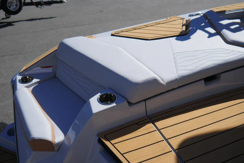 Slide: The Image of 2026 Nautique Super Air Nautique G23 boat interior with cushioned seating and cup holders. - 21