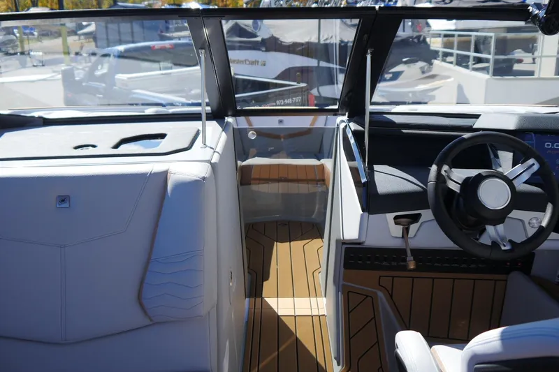 Slide: The Image of 2026 Nautique Super Air Nautique G23 boat interior with modern steering and sleek design. - 27
