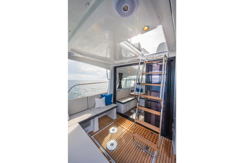 Slide: The Image of 2025 Beneteau Antares 11 Fly interior with seating, wooden flooring, and ladder. - 23