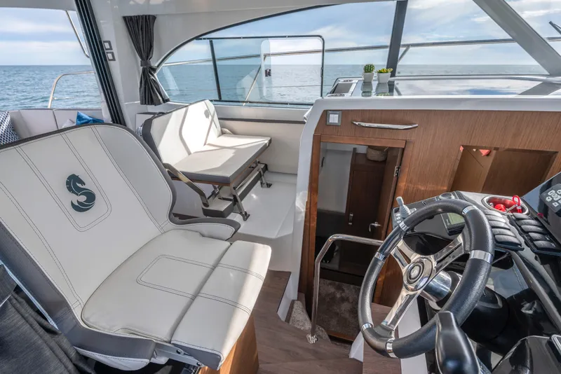 Slide: The Image of Interior of 2025 Beneteau Antares 11 Fly, featuring helm and seating with ocean view. - 7