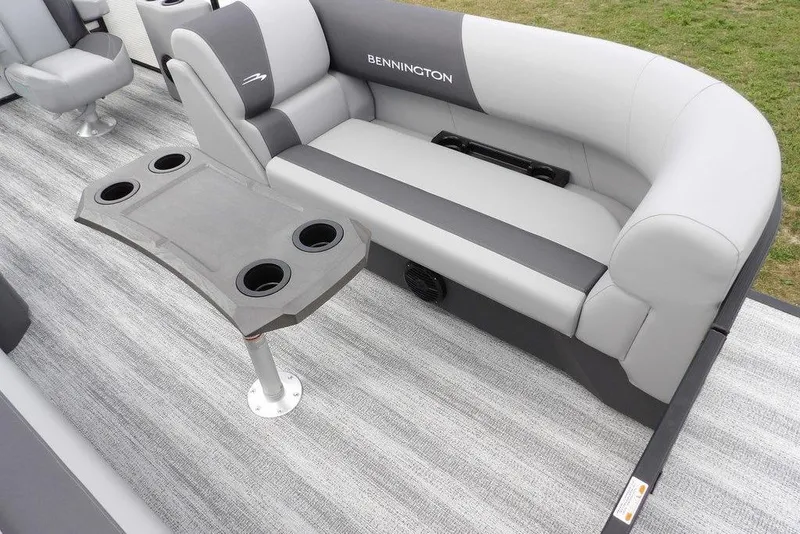 Slide: The Image of 2026 Bennington S Swingback 22 SSB boat interior with gray seating and cupholder table. - 14