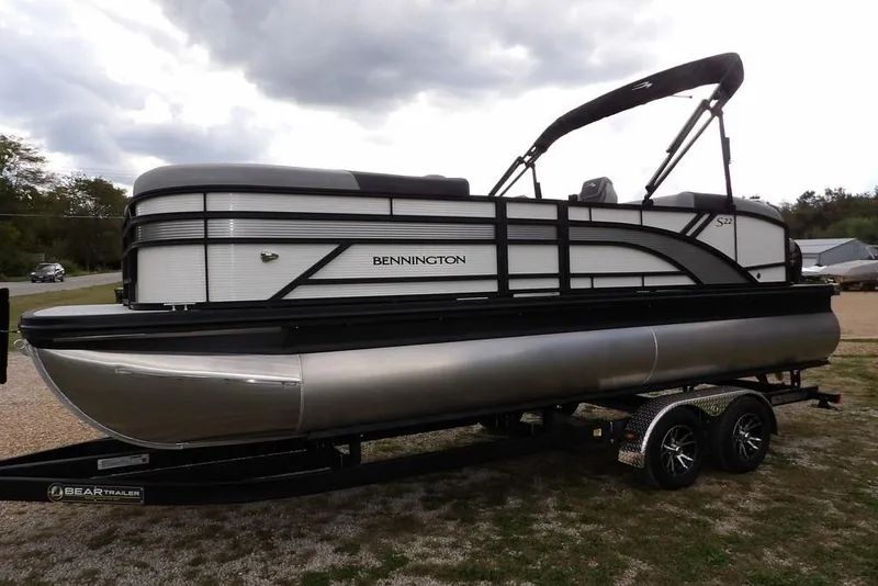 Slide: The Image of 2026 Bennington S Swingback 22 SSB pontoon boat on trailer, under cloudy sky. - 4