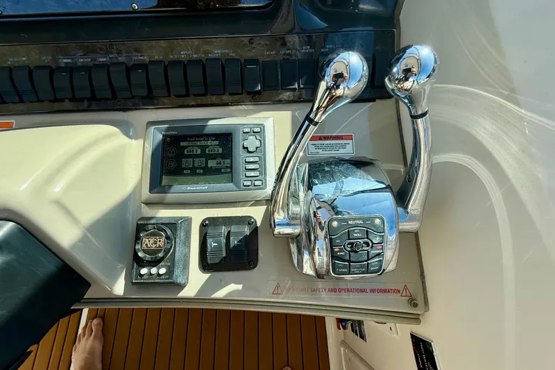Slide: The Image of Control panel of a 2008 Sea Ray 38 Sundancer boat with throttle levers and display. - 13
