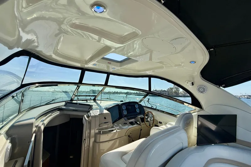 Slide: The Image of 2008 Sea Ray 38 Sundancer yacht interior with helm, luxurious seating, and panoramic windows. - 18