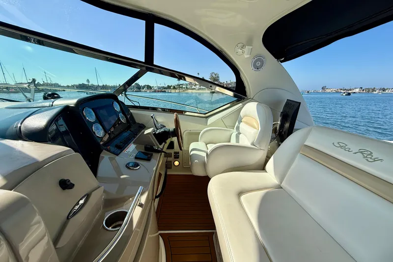 Slide: The Image of 2008 Sea Ray 38 Sundancer cockpit with luxurious seating and modern controls, overlooking serene waters. - 20