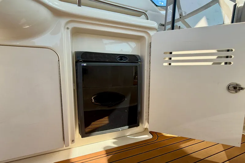 Slide: The Image of 2008 Sea Ray 38 Sundancer interior with open cabinet and mini fridge. - 22