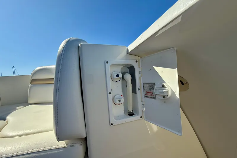 Slide: The Image of 2008 Sea Ray 38 Sundancer boat seating with open utility compartment under clear blue sky. - 27