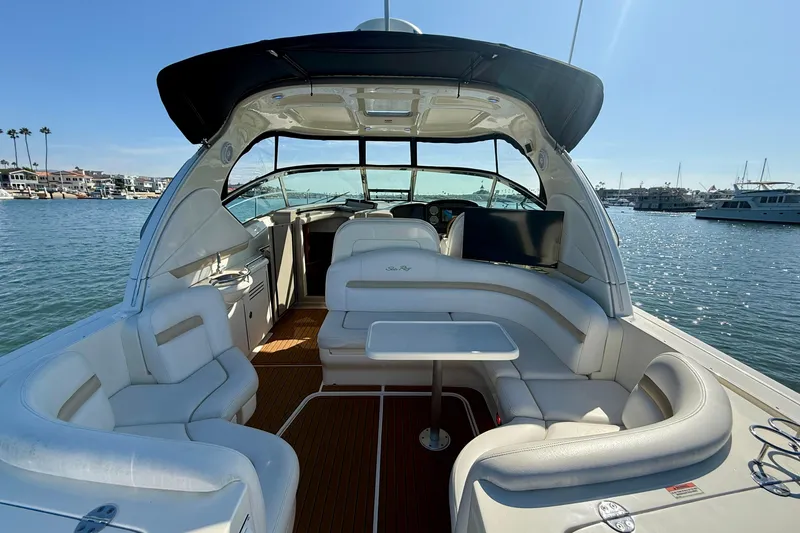 Slide: The Image of 2008 Sea Ray 38 Sundancer yacht interior with white seating and table, docked in a marina. - 29