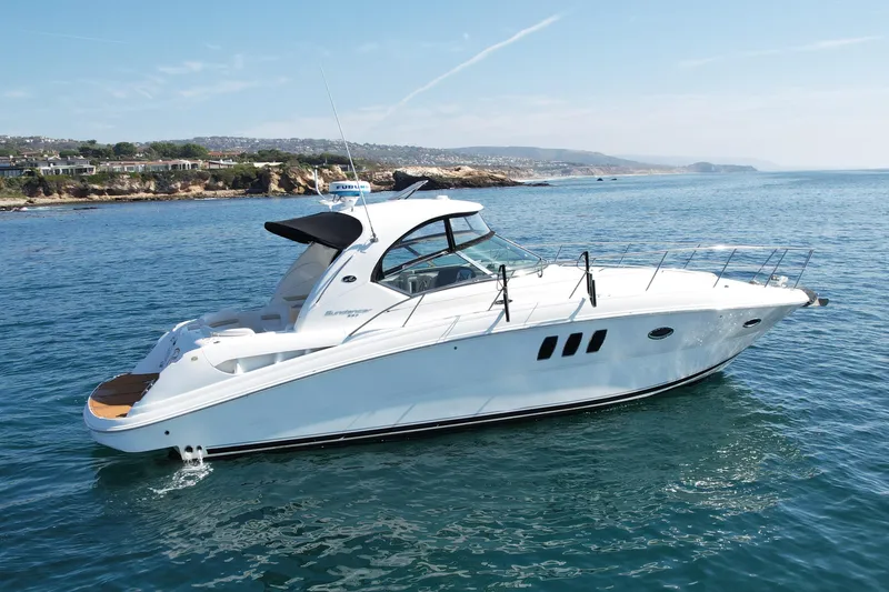 Slide: The Image of 2008 Sea Ray 38 Sundancer yacht cruising on a sunny day near rocky coastline. - 3