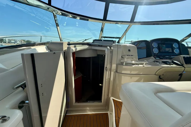 Slide: The Image of 2008 Sea Ray 38 Sundancer cockpit with helm, open cabin door, and panoramic windows. - 31