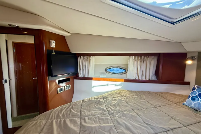 Slide: The Image of Interior cabin of 2008 Sea Ray 38 Sundancer with bed, TV, and porthole window. - 34