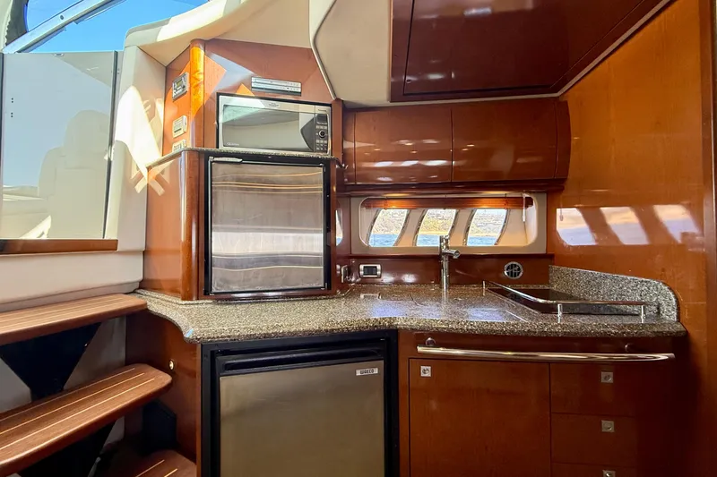 Slide: The Image of 2008 Sea Ray 38 Sundancer yacht kitchen with wood cabinetry and modern appliances. - 49