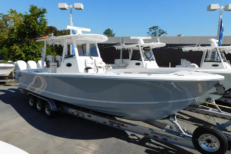 Slide: The Image of 2026 Regulator 35 boat on trailer, displayed outdoors under clear blue sky. - 107
