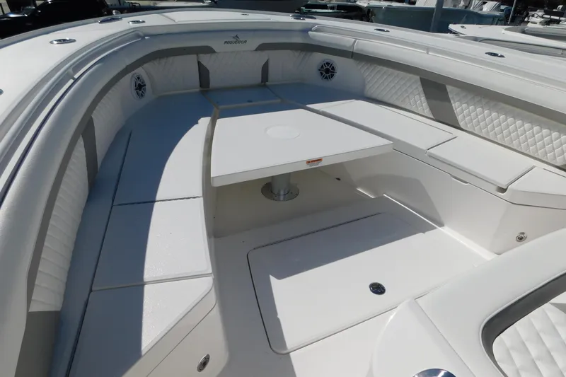 Slide: The Image of 2026 Regulator 35 boat interior with white seating and table, featuring quilted upholstery. - 49