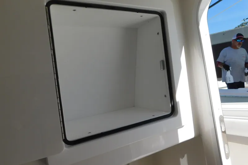 Slide: The Image of Open storage compartment on 2026 Regulator 35 boat with person in background. - 60