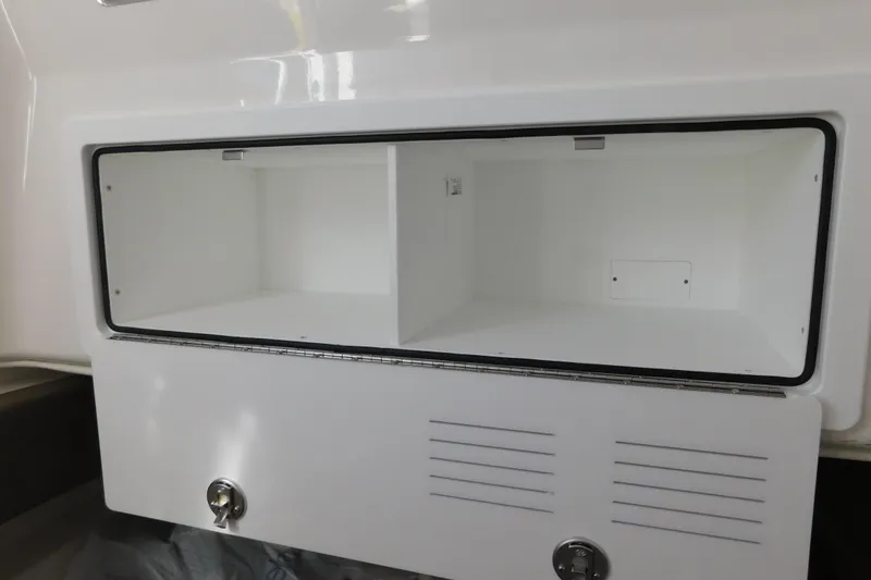 Slide: The Image of 2026 Regulator 35 boat storage compartment with open hatch and secure lock. - 63