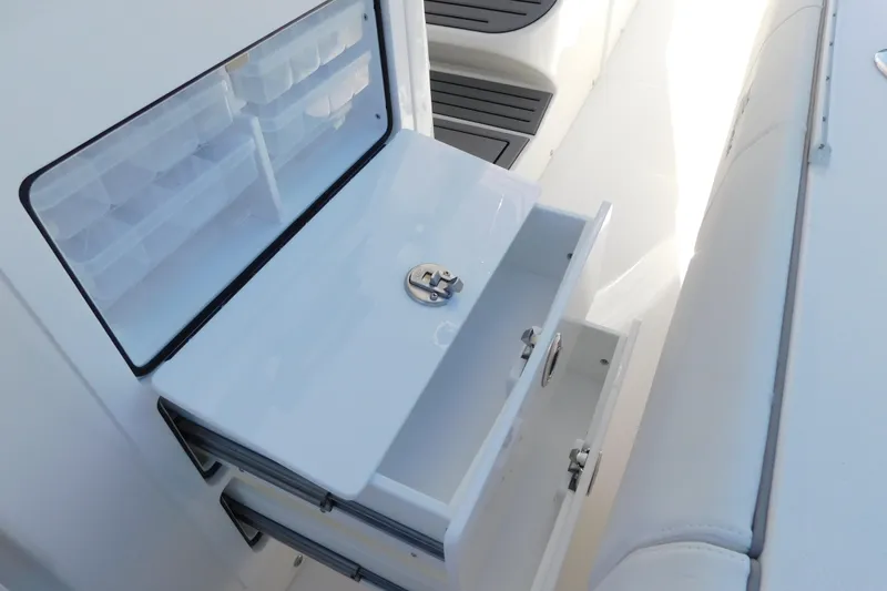 Slide: The Image of 2026 Regulator 35 boat storage compartment with open drawers and tackle boxes. - 74