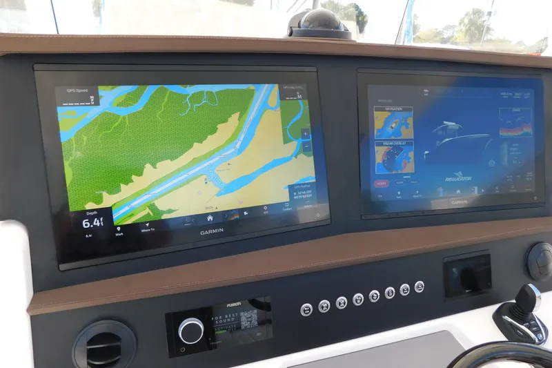 Slide: The Image of 2026 Regulator 35 boat dashboard with dual Garmin navigation screens displaying maps and controls. - 8
