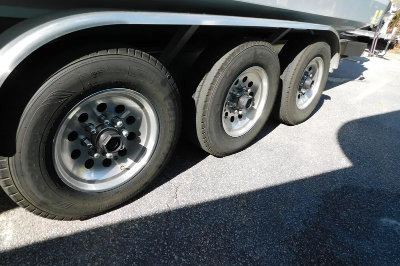 Slide: The Image of Triple axle trailer wheels of a 2026 Regulator 35 boat on pavement. - 97