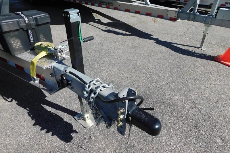 Slide: The Image of Trailer hitch and safety chains on a 2026 Regulator 35 boat trailer. - 99