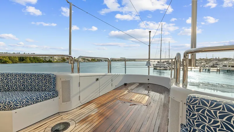 Slide: The Image of Luxury yacht deck with patterned seating, wooden flooring, and scenic waterfront view. New Zealand Yachts Wave Piercer 2005. - 11