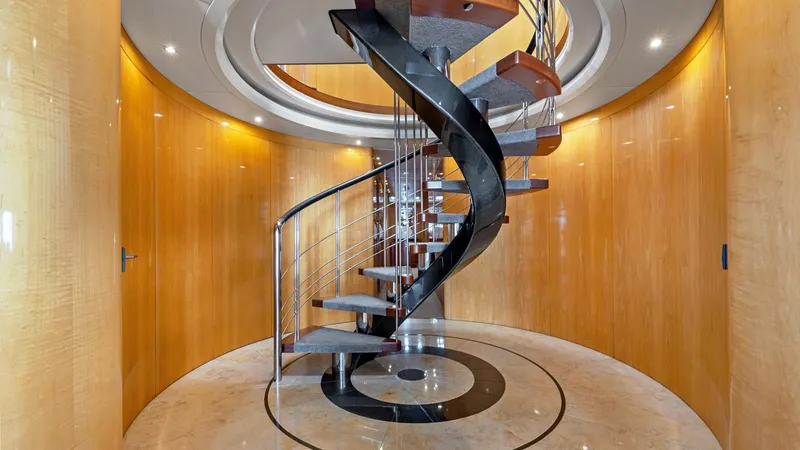 Slide: The Image of Luxurious spiral staircase inside 2005 New Zealand Yachts Wave Piercer, featuring elegant wood paneling. - 26