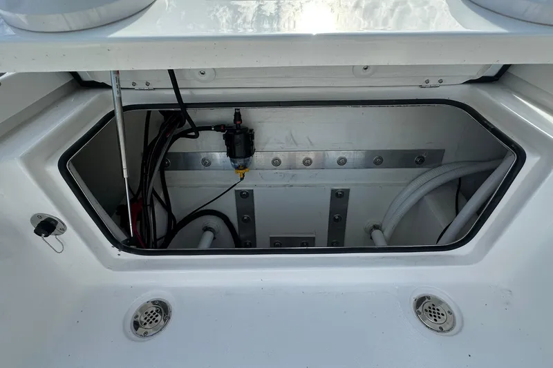 Slide: The Image of Open storage compartment on 2026 Delta Boatworks Delta D245, showcasing interior components and wiring. - 16