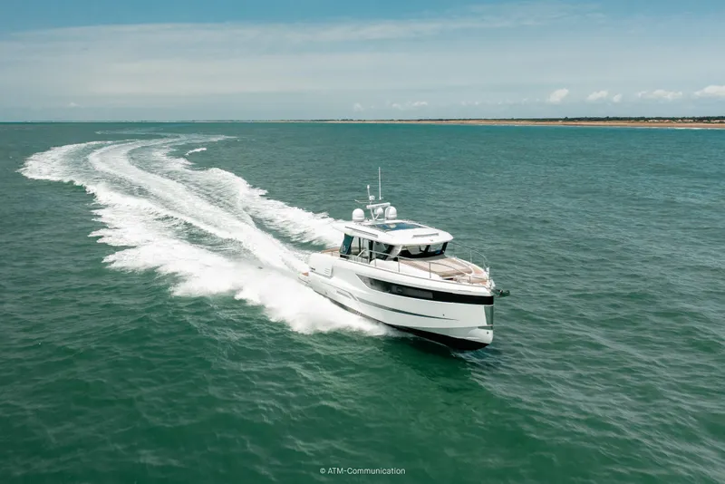 Slide: The Image of 2026 Wellcraft 44 Explorer yacht cruising on open sea under clear skies. - 2