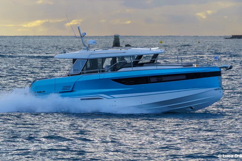 Slide: The Image of 2026 Wellcraft 44 Explorer yacht cruising on open water at sunset. - 7