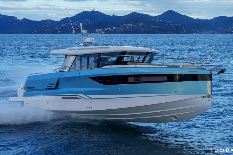 Slide: The Image of 2026 Wellcraft 44 Explorer yacht cruising on open water with scenic mountain backdrop. - 8