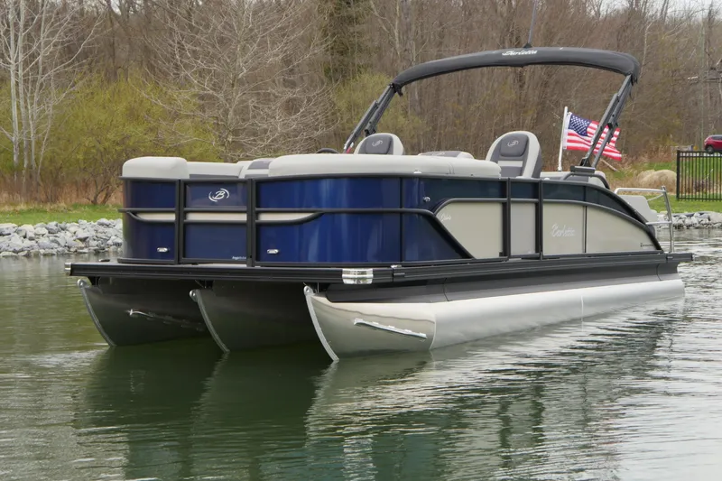 Slide: The Image of 2025 Barletta Cabrio 22UC pontoon boat on calm water with American flag. - 2