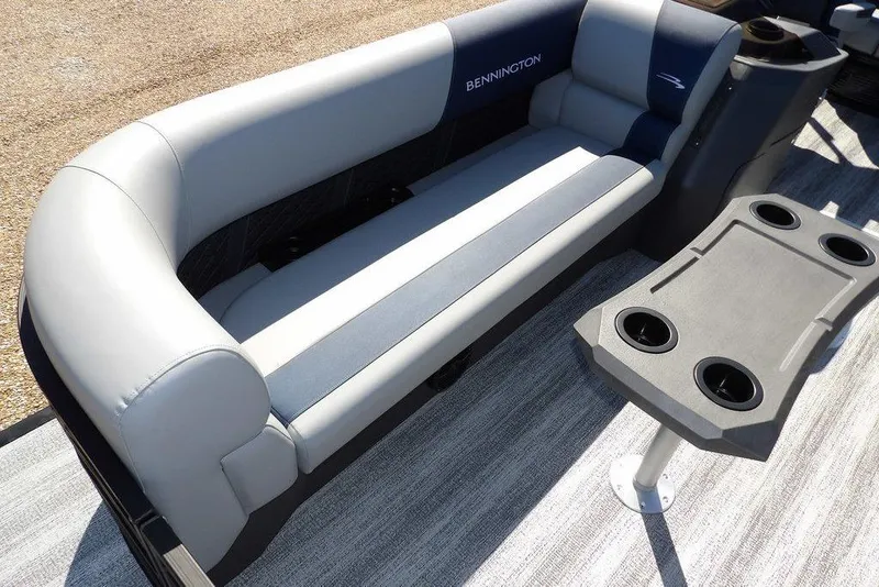 Slide: The Image of 2026 Bennington S Swingback 22 SSB boat interior with gray seating and cup holder table. - 8