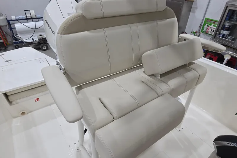 Slide: The Image of 2026 Boston Whaler 220 Dauntless boat seat with beige upholstery and armrests. - 27