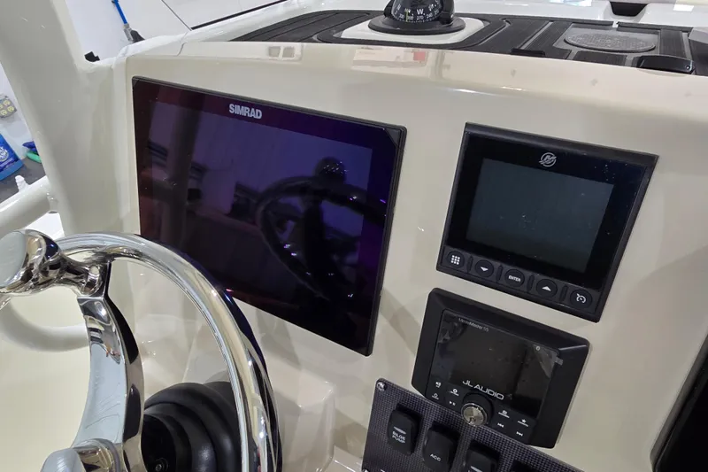Slide: The Image of 2026 Boston Whaler 220 Dauntless dashboard with Simrad display and controls. - 52