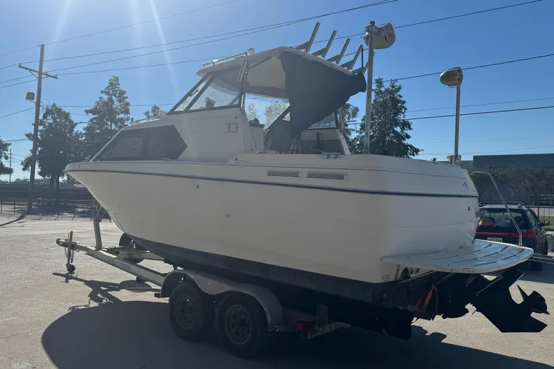 Slide: The Image of 1998 Bayliner 2452 Ciera Express boat on trailer under clear blue sky. - 18