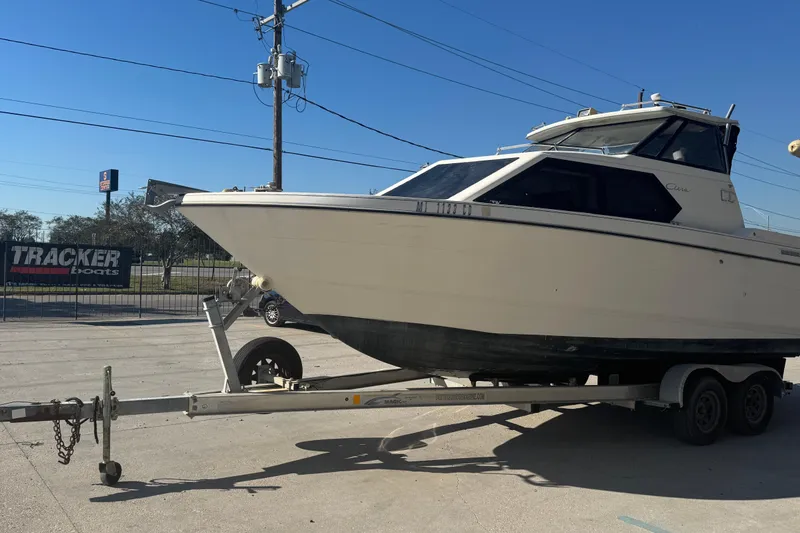 Slide: The Image of 1998 Bayliner 2452 Ciera Express boat on trailer, parked outdoors under clear blue sky. - 19