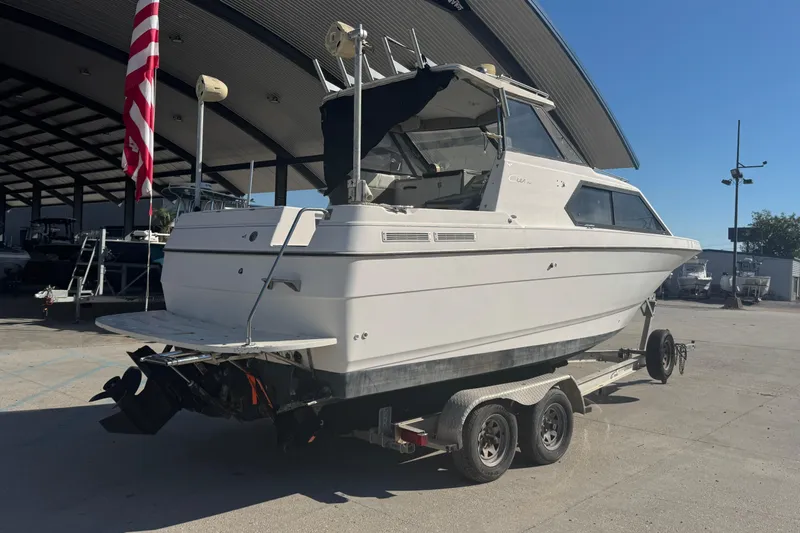 Slide: The Image of 1998 Bayliner 2452 Ciera Express boat on trailer, parked outdoors under a canopy. - 3