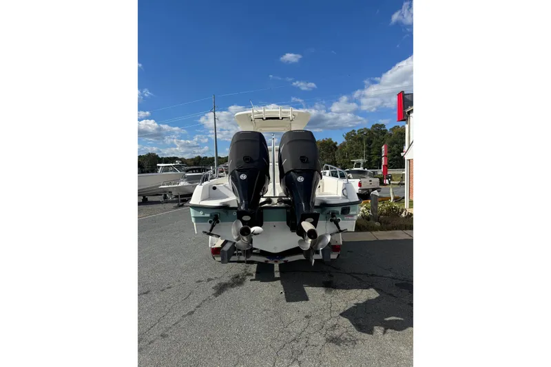 Slide: The Image of 2014 Boston Whaler 270 Dauntless boat with dual outboard motors, parked outdoors. - 12