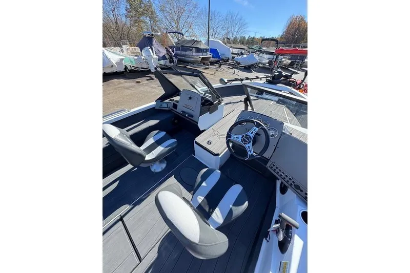 Slide: The Image of 2026 Vexus ADX 190 boat interior with steering wheel and seating, parked outdoors. - 10