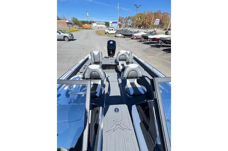 Slide: The Image of 2026 Vexus ADX 190 boat with sleek seating and modern design in a parking lot. - 7