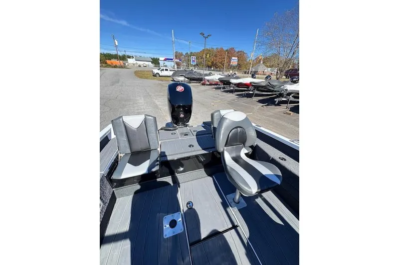 Slide: The Image of 2026 Vexus ADX 190 boat interior with seating and motor, parked outdoors. - 8