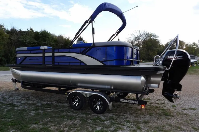 Slide: The Image of 2026 Bennington S Quad Bench 22 SSR pontoon boat on trailer, parked outdoors. - 6
